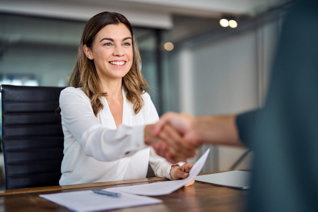 Lawyer shaking hands with a client in her office